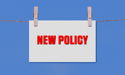 NEW POLICY Symbol. Concept words NEW POLICY on White Rectangle Paper Hanging on a Wooden Clothespin...