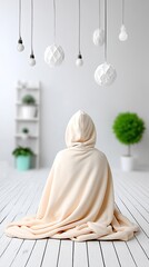 Person Wrapped in a Beige Hooded Blanket Sitting on White Wooden Floor in Minimalist Interior