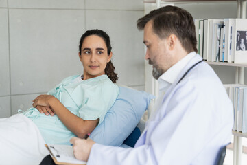 Obraz premium Specialist doctors providing medical treatment and discussing test results with patients in a hospital setting. Healthcare and wellness concept.