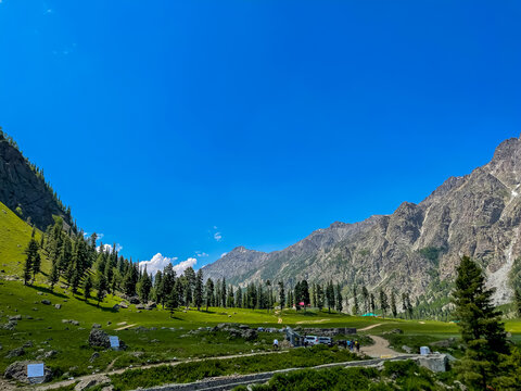 Lush green valley and majestic mountains near Rainbow Lake, Astore, Pakistan. Captured under a clear blue sky, showcasing the serene beauty of northern Pakistan's alpine region.
