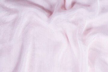 Soft smooth pink silk fabric background. Fabric texture.