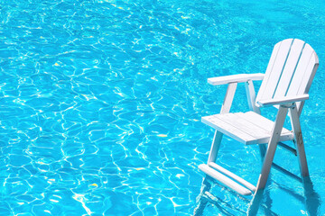 Serene swimming pool scene featuring white chair resting on water surface, inviting relaxation and tranquility