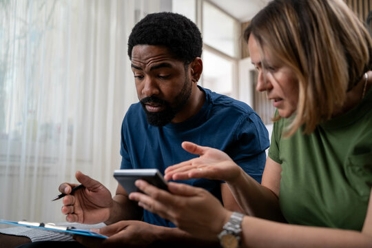 Interracial couple worried about financial problems at home, rising food prices, unpaid bills and credit debt stress.