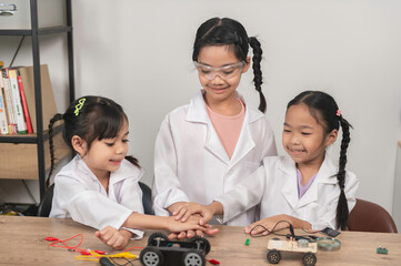 Asian littlle girl constructing and coding robot at STEM class,Fixing and repair mechanic toy car