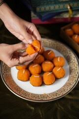 hand holding a bowl of orange fruit