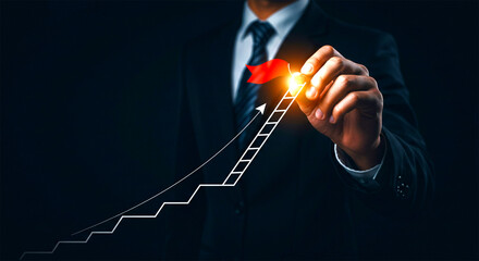 Man in suit drawing growth graph showing business progress success and positive financial...
