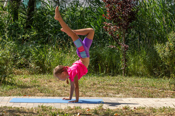 Child balancing in a one-legged handstand pose
