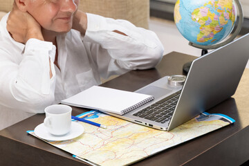 Man engaged in online learning while exploring maps and preparing for travel
