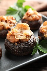 Delicious stuffed mushrooms with parsley on table, closeup