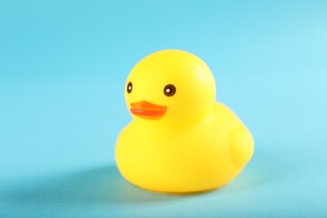 One cute rubber duck on light blue background, closeup