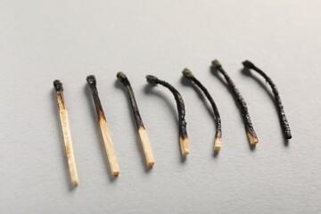 Burnt matches on grey background, closeup view