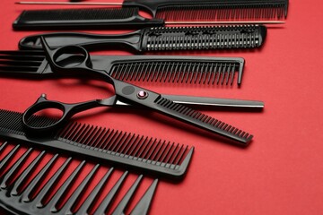 Different hairdresser's tools on red background, closeup