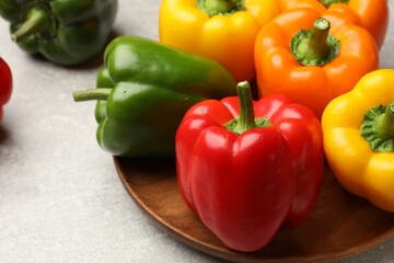 Fresh colorful bell peppers on gray textured table, closeup