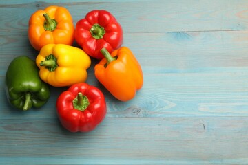 Fresh colorful bell peppers on blue wooden table, flat lay. Space for text