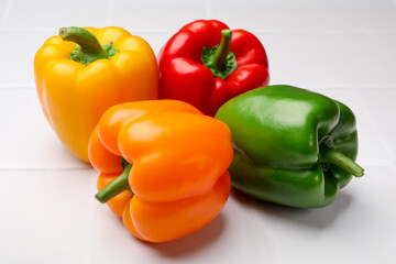 Fresh colorful bell peppers on white table, closeup