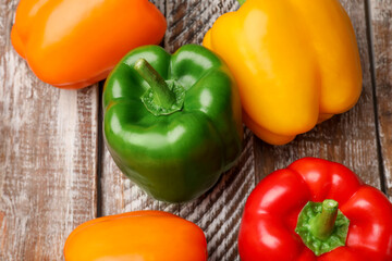 Fresh colorful bell peppers on wooden table, flat lay