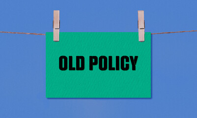 OLD POLICY Symbol. Concept words OLD POLICY on Green Rectangle Paper Hanging on a Wooden Clothespin...