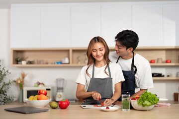 Couple Cooking Together with Fresh Ingredients in Modern Kitchen. Love and joy in food preparation.