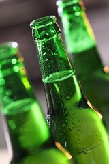 Bottles of beer on blurred grey background, macro view