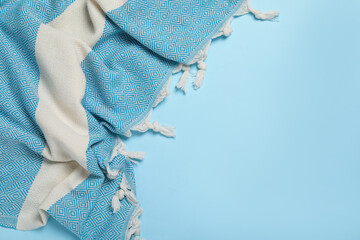 Striped beach towel on light blue background, top view. Space for text