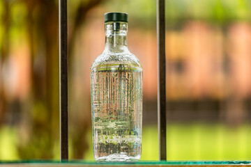Clear bottled water with an out-of-focus nature background