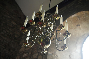 Oxton, Nottinghamshire, England - June 20 2025: Ornate chandelier with candle-shaped light fixtures...