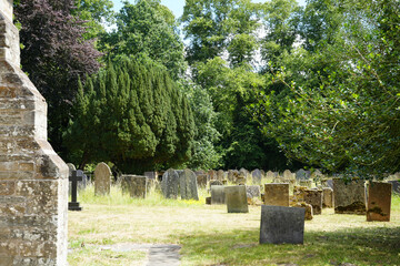 Oxton, Nottinghamshire, England - June 20 2025: A traditional churchyard cemetery with old grave...