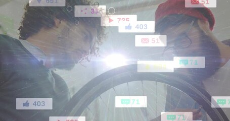 Colleagues rotating bicycle wheel and activating multiplying social media icons for engagement - Powered by Adobe