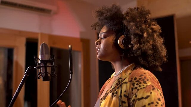 Young singer recording new song in professional studio