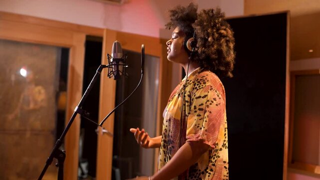 Young singer recording new hit song in professional studio