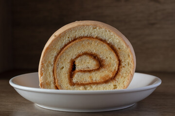 Slice of Jam-Filled Swiss Roll on White Plate