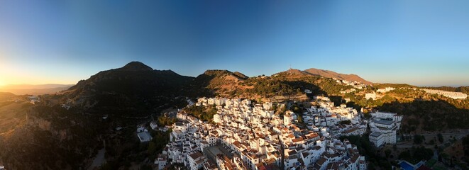 An aerial view captures the dense cluster of whitewashed houses with terracotta roofs, built into...