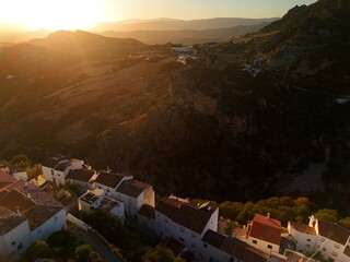 An aerial view captures the dense cluster of whitewashed houses with terracotta roofs, built into...