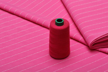 Flatlay of pink suiting fabric with white line pattern—ideal textile background for fashion,...