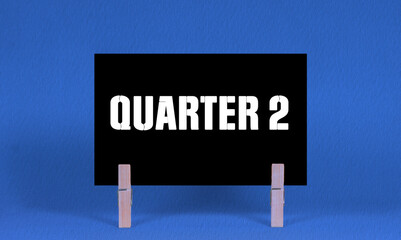 QUARTER 2 Symbol. Concept words QUARTER 2 on Black Rectangle Paper Held by Wooden Clothespin Blue...