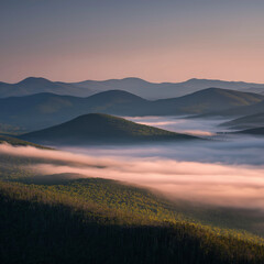 Obraz premium Fog drifting between green mountain layers during early morning sunrise
