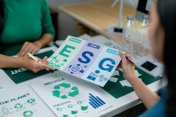 Businesswomen discussing about esg report with environmental, social, and governance icons during a...