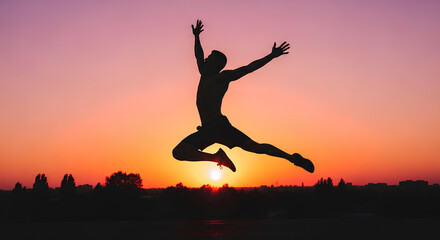 Silhouette of male athlete performing leap at sunset, strong pose and dramatic sky.