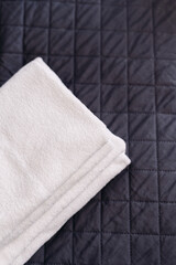Soft towels on a plush bedspread, creating a relaxing hotel bedroom atmosphere