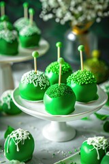 Simple Saudi flag-colored round cake pops cupcakes, green base with white toppings. patriotic desert for September 23 celebrations.