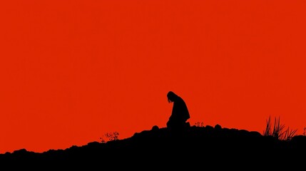 Naklejka premium Silhouette of a figure in prayer against a vibrant red sky during dusk