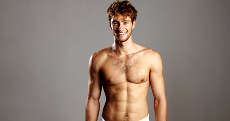 Portrait, man and shirtless for skincare in studio for natural beauty, bodybuilding and abs. Smile,...