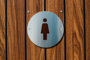Modern women restroom sign on wooden wall indicates facility access clearly