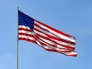 Large national flag of the United states of America, the Stars and Stripes, isolated against a...