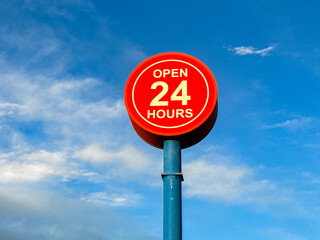 Open 24 hours sign isolated against a blue sky. No people, Copy space.