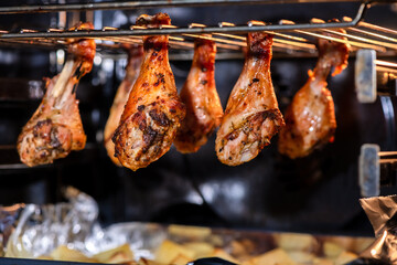Juicy chicken drumsticks roasting on an oven rack, with golden baked potatoes beneath. Perfectly cooked meal showcasing a delicious combination of flavors and textures
