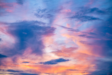 Captivating sunset sky filled with vibrant hues of orange, pink, and purple, creating a dramatic and serene atmosphere. Wispy clouds enhance the beauty of the evening sky
