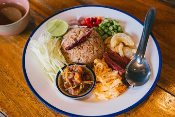 Delicious traditional rice dish with flavorful toppings and fresh ingredients on a wooden table setting