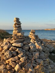 Beach stones on top of each other over sea background outdoors.