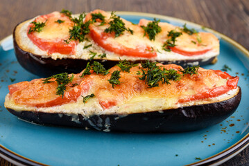 Close-up of baked eggplants with tomatoes under cheese.